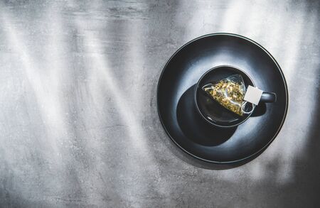 Tea cup on saucer with bag. Top view. Teabag in teacup. Isolated on gray. Blank free space for your advertising or text. Copyspaceの写真素材