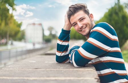 Happy smile young man. Portrait of cheerful guy in the park, outdoor - outside, copy spaceの写真素材