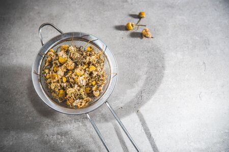 Chamomile tea dried petals - loose flowers on infuser, on gray backgroundの写真素材