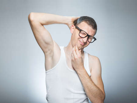 Man waking in morning, guy wearing undershirt and stretching over gray backgroundの写真素材
