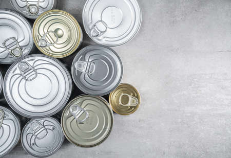 Group of tin cans on gray background. Conserved food with copy space for textの写真素材