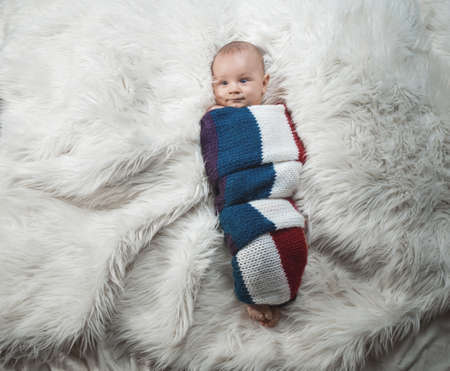 Cute baby boy on bed, studio shotの写真素材