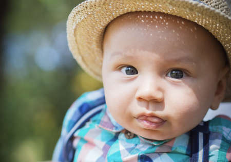 Face of a baby boy, outdoors, outside. Close up of child