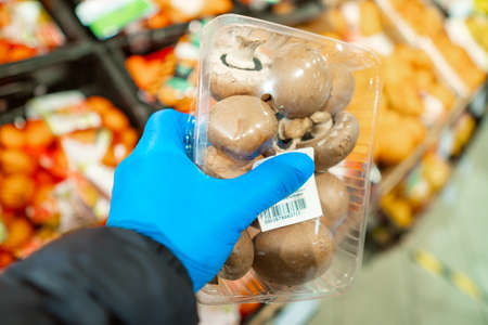 Buying supplies at nutrition during virus. Close up hand with product in supermarketの写真素材