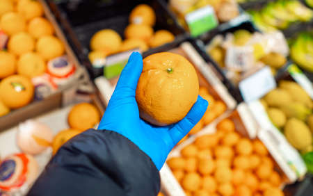 Buying supplies at nutrition during virus. Close up hand with product in supermarketの写真素材