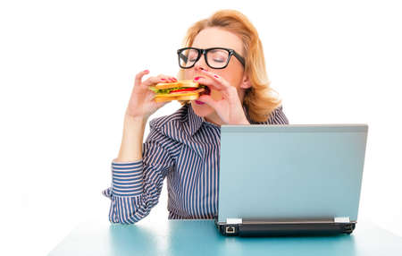 Hungry girl eating sandwich on work, isolatd on white. Studio shot