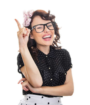 Cheerful happy young woman gesturing. Smile pin up girl pointing up, isolated on whiteの写真素材