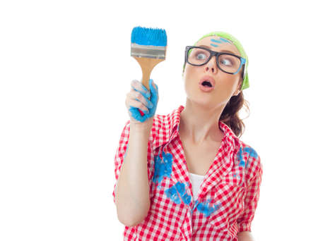 Funny surprised woman painter holding paint brush, girl ready for renovating or painting, isolated on whiteの写真素材