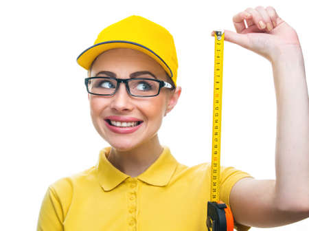 Cheering young woman worker holding meter, isolated on white background. Portrait of a manual...