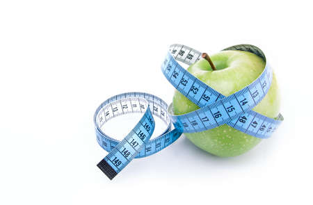 Dieting concept green apple with measuring tape isolated on white