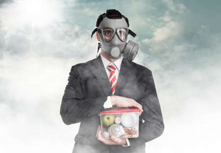 Business man with gas mask holding nutrition, survival conceptの写真素材