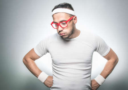 Lazy funny sport man does not wish to doing fitness - exercising. Isolated on gray background. Studio shotの写真素材