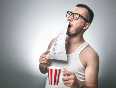 Man yawning and holding newspaper in front of their mouth. Sleepy exhausted funny businessman with...