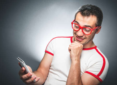 Funny guy looking to mobile phone - smartphone see something interesting