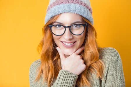 Beautiful smiling trendy girl, isolated on yellow background. Head and shoulders front view of laughing blond happy woman. Studio shotの写真素材