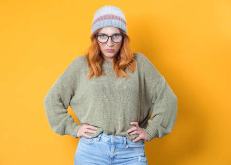 Strict young woman, isolated on yellow background. Jealous pretty girl. Studio shotの写真素材