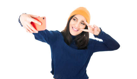 Selfie. Girl takes photo of himself with her smartphone, isolated on white background. Studio shot