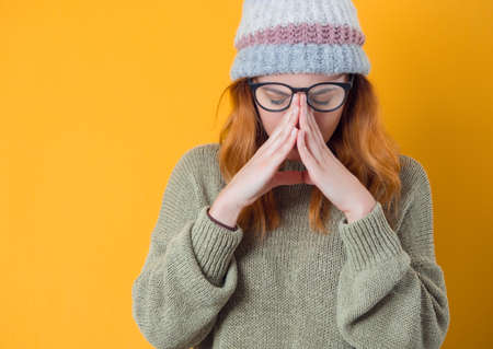 Migraine. Young woman suffering from headache, isolated on yellow background. Exhausted girl. Studio shotの写真素材