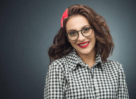 retro style young woman over dark gray - black background. Half length of vintage girl posing with smile expression. Studio shotの写真素材