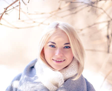 Portrait of the beautiful girl of the blonde with green eyes. Sunny winter day. Toned in warm colorsの写真素材