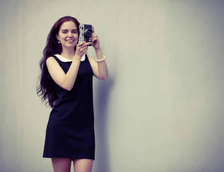 Beautiful sexy brunette with long hair with vintage camera in hand,の写真素材