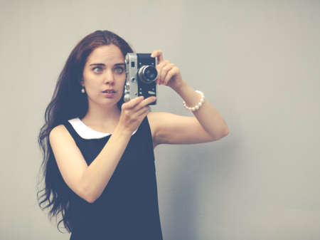 Beautiful sexy brunette with long hair with vintage camera in hand,の写真素材