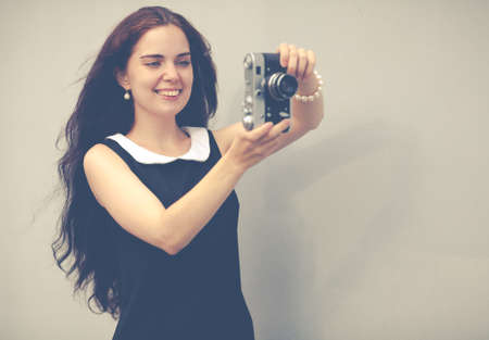 Beautiful sexy brunette with long hair with vintage camera in hand,の写真素材