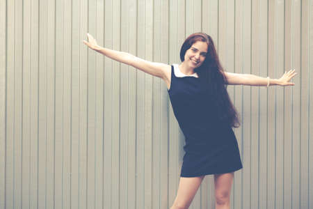 Young pretty crazy funny brunette girl have fun and goes wild alone on the street on silver background urban styleの写真素材