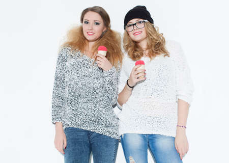 Fashionable beautiful girl eating ice cream and fun posing near a white wall. Indoor. Studioの写真素材