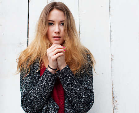 Beautiful girl with long hair in the winter is cold and warms his hands