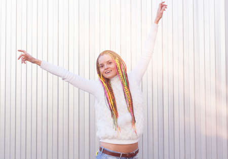 Beautiful girl with dreadlocks sunny summer day posing near the wall fun outdoorの写真素材