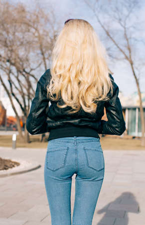 Pretty young fashion sexy girl with beautiful long blond hair on the road in evening summer time...