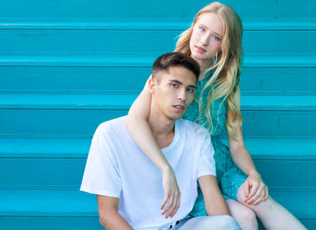beautiful young couple sitting on the stairs a warm summer eveningの写真素材