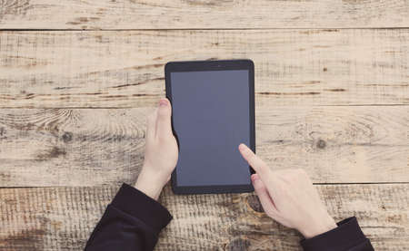 Digital tablet computer with isolated screen in male hands. Top view with copy space. Free space for text. Hipster styleの写真素材