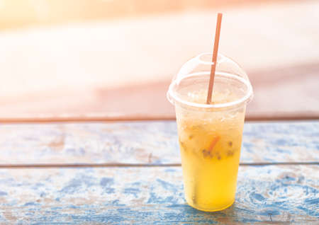 Refreshing cold drink with fresh lime, passionfruit and ice. On wooden planks. Background. Freshment. Summertime.の写真素材