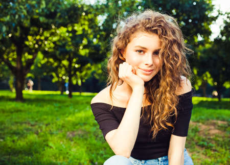 Beautiful young brunette woman with long hair relaxing in the garden on a warm summer evening. Warm color. Portrait, close-up. Harvestingの写真素材