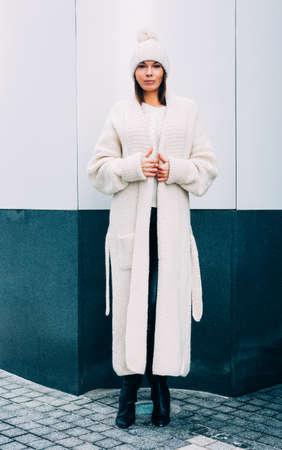 Fashionable stylish girl in white cap and knit coat. Outdoor. Streetstyle.の写真素材