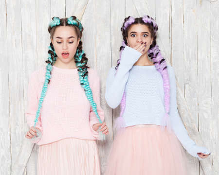 Portrait of two girls in fashionable outfits with colored braids girlfriends having fun and indulging. Outdoor.の写真素材