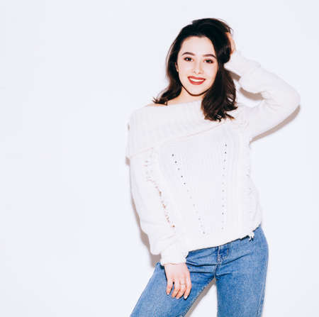 Elegant european lady in vintage sweater posing on white background. Indoor portrait of pleased...