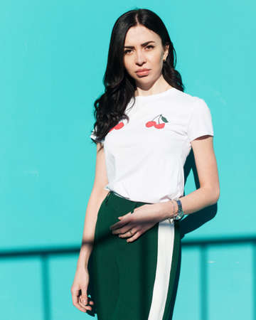 Fashionable girl blogger posing in trendy outfit on a turquoise background in the street. Fashion.の写真素材