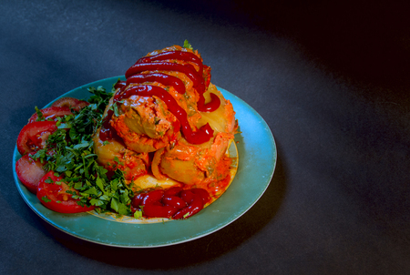 Meat with cabbage and vegetables on a plate shot closeup on a black backgroundの写真素材