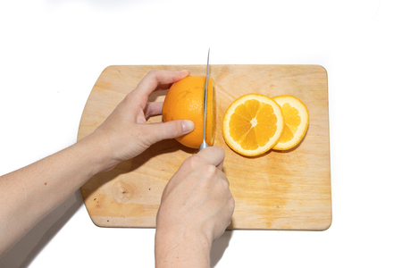 A cutting of an orange on a whiteboard is isolated on a white background. Fruits on the board. Fruits on a white background. Cutting fruit.の写真素材