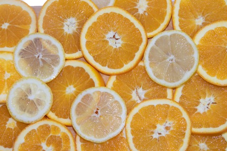 Sliced orange and lemon on a board isolated on white background. Fruits on the board. Fruits on a white background. Cutting fruit. Sliced fruitの写真素材