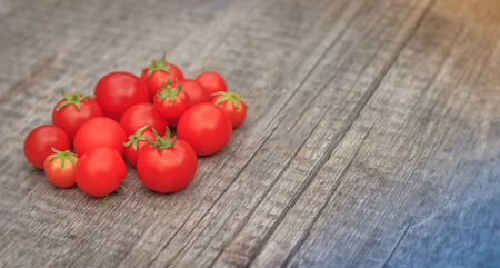 Cherry tomatoes on a wooden background. Autumn harvesting. Homemade vegetables.の写真素材