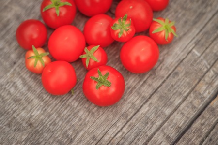 Cherry tomatoes on a wooden background. Autumn harvesting. Homemade vegetables.の写真素材