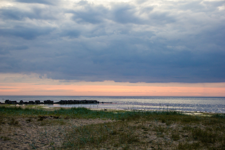A bright sunset on the Gulf of Finland. Sunset at the sea. Sunset on the Gulf. warm summer, crimson sky and small wavesの写真素材