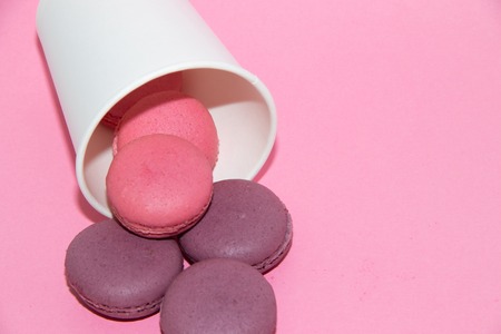 Macaroni on a gently pink background. Delicious cakes for tea. Dessert close-up. Bakery products.の写真素材