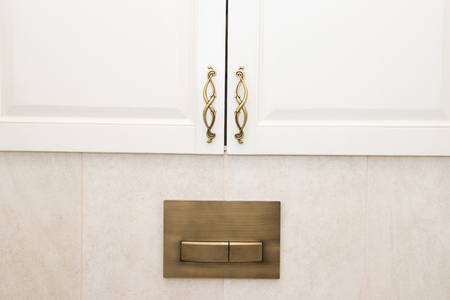 Dark handle on the white facade of the cabinet. Furniture fittings. Open and close the cabinet.の写真素材