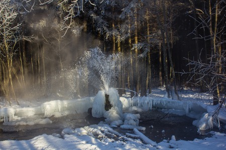 Gatchina geysers in winter. A jet of water up from the ground. Ice growths from water
