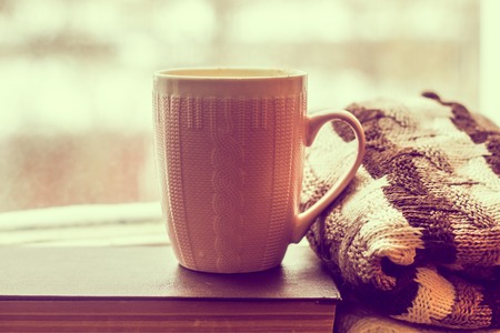 Coffee and a sweater on the book by the window. bad mood. relax